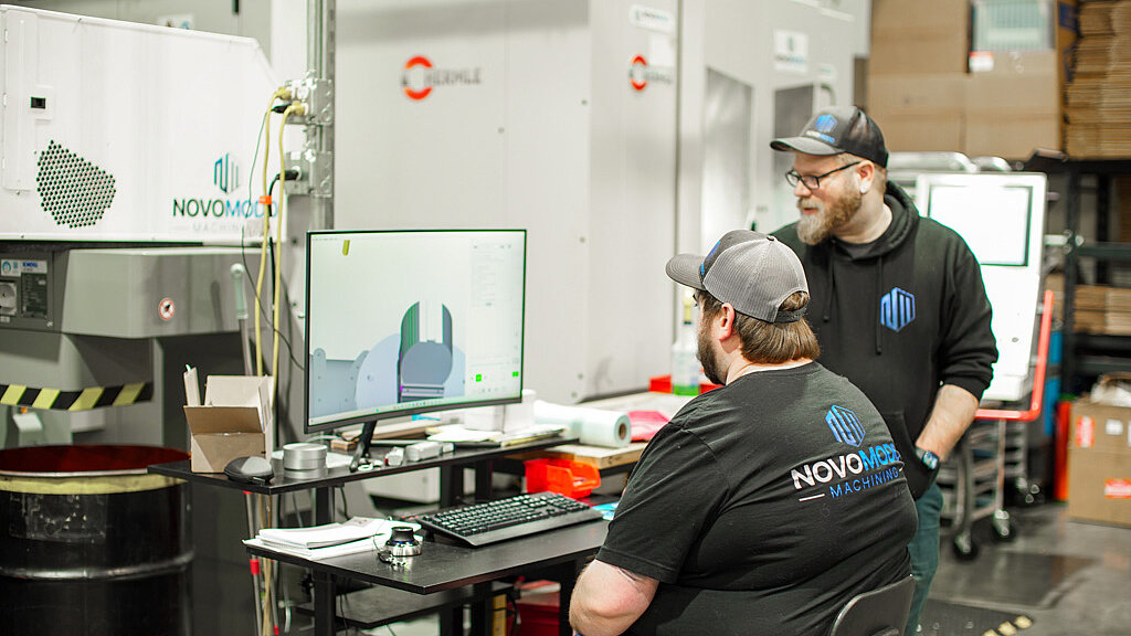 Novo Modo machinists, Kevin Ramos and Phil Hilt, eview designs for an automotive component before importing to the HERMLE C 250 machine