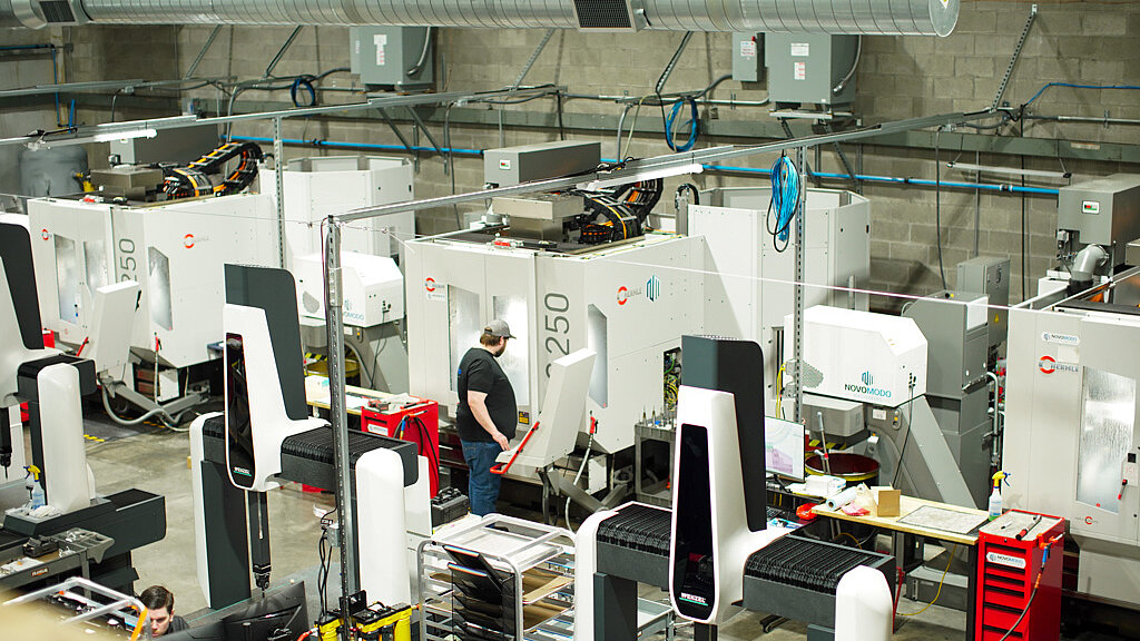 CNC Machinist, Kevin Ramos, inspects production on Novo Modo’s HERMLE C 250 5-axis machine.