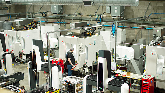 CNC Machinist, Kevin Ramos, inspects production on Novo Modo’s HERMLE C 250 5-axis machine.
