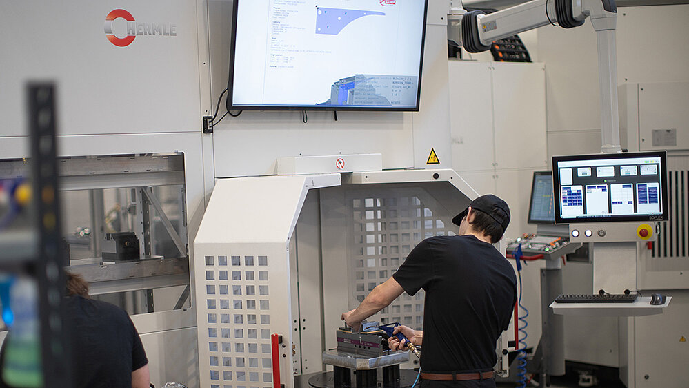 STIWA US CNC operator cleans finished part before loading next piece into production. 